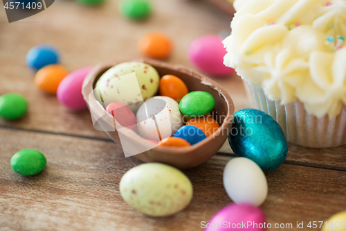 Image of close up of chocolate egg with candies and cupcake