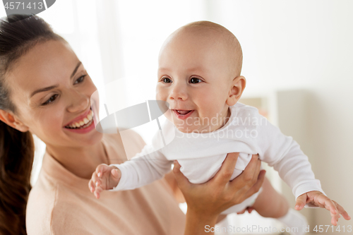 Image of happy mother playing with little baby boy at home