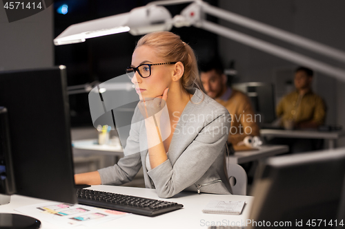 Image of businesswoman working at computer in night office