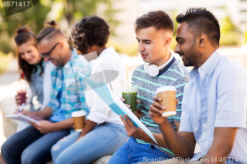 Image of students with notebook and takeaway drinks