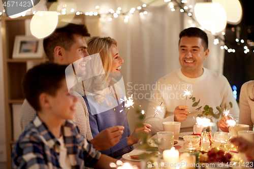 Image of family with sparklers having tea party at home