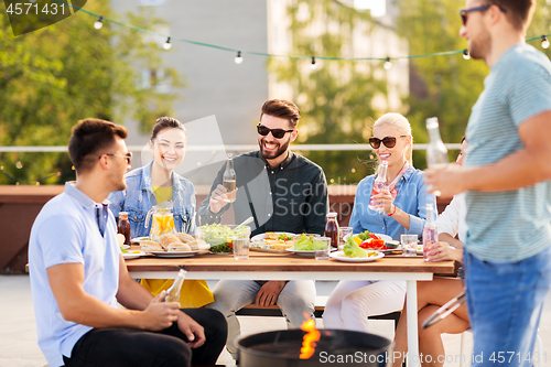 Image of happy friends having bbq party on rooftop