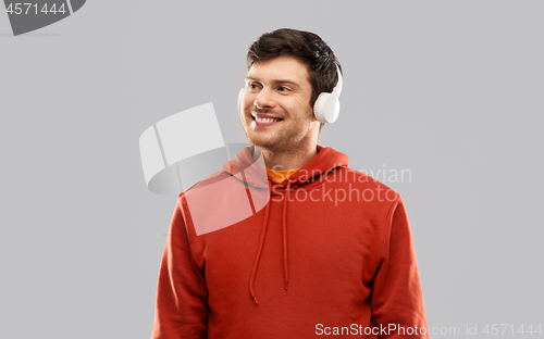 Image of happy young man in headphones and red hoodie