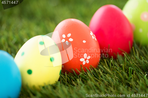 Image of row of colored easter eggs on artificial grass