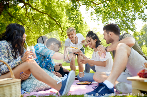 Image of friends with drinks and food at picnic in park