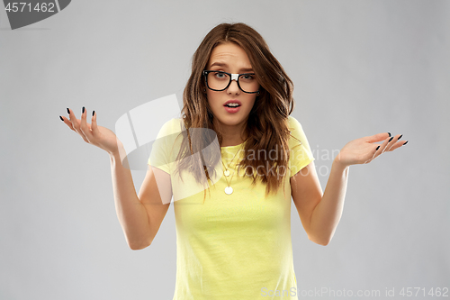 Image of young woman or teenage girl in glasses shrugging