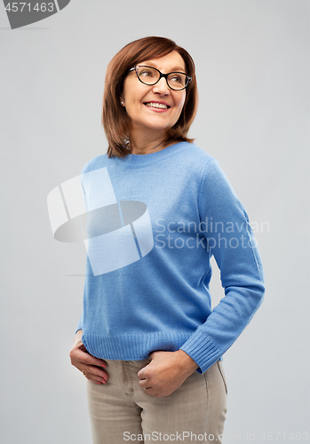 Image of portrait of senior woman in glasses over grey