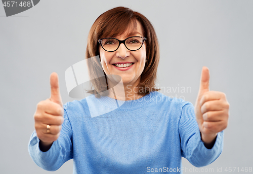Image of portrait of senior woman showing thumbs up