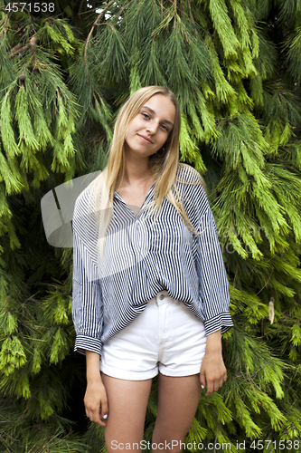 Image of Beautiful young woman wearing elegant clothes standing in the fo