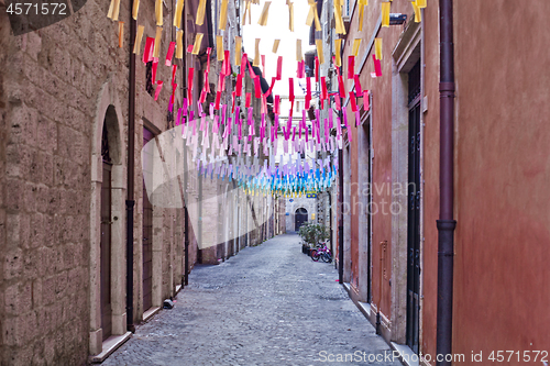 Image of Colorful paper flags over italian street.