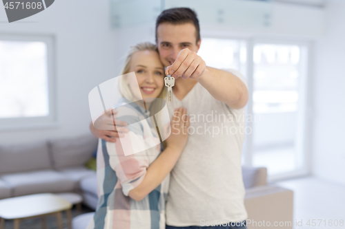 Image of couple showing a keys of their new house