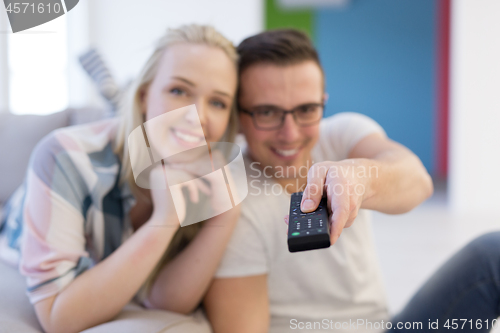 Image of Young couple on the sofa watching television