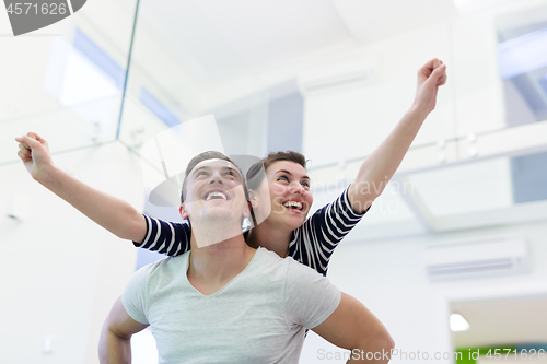 Image of handsome man piggybacking his girlfriend