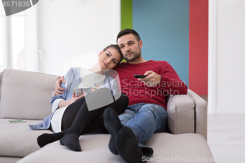 Image of Young couple on the sofa watching television