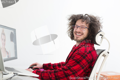 Image of graphic designer in bathrobe working at home
