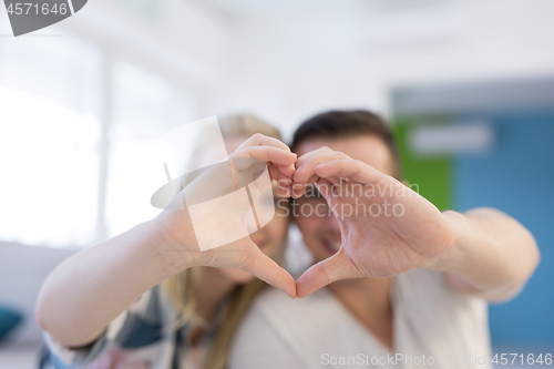 Image of couple making heart with hands