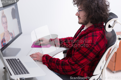 Image of graphic designer in bathrobe working at home