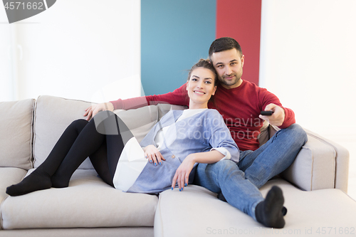 Image of Young couple on the sofa watching television