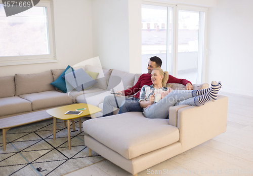 Image of Young couple on the sofa watching television