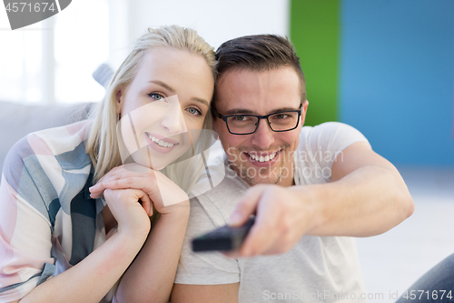 Image of Young couple on the sofa watching television