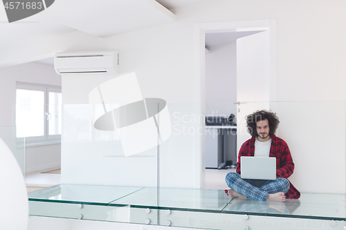 Image of young freelancer in bathrobe working from home