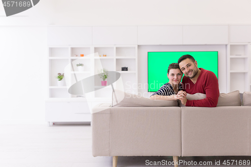 Image of couple hugging and relaxing on sofa