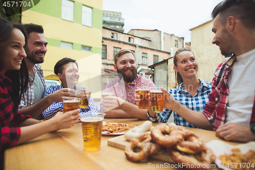 Image of The group of friends enjoying drink at outdoor bar