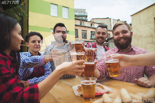 Image of The group of friends enjoying drink at outdoor bar