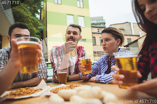 Image of The group of friends enjoying drink at outdoor bar