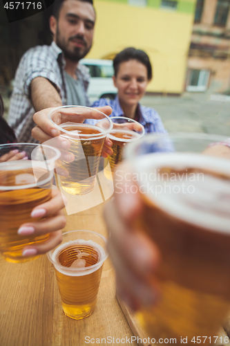 Image of The group of friends enjoying drink at outdoor bar