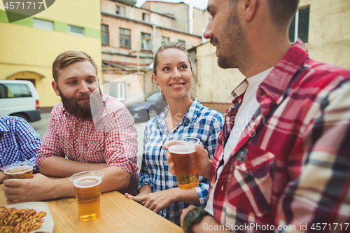 Image of The group of friends enjoying drink at outdoor bar