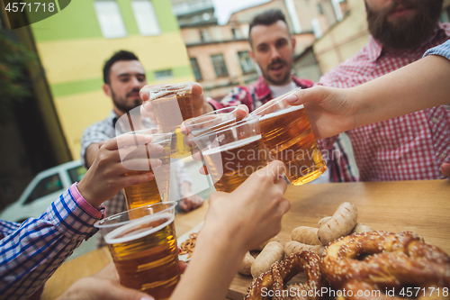 Image of The group of friends enjoying drink at outdoor bar