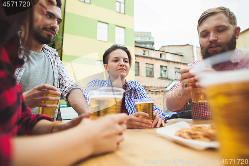 Image of The group of friends enjoying drink at outdoor bar