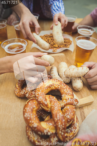 Image of Boiled white sausages, served with beer and pretzels. Perfect for Octoberfest. Natural wooden background.