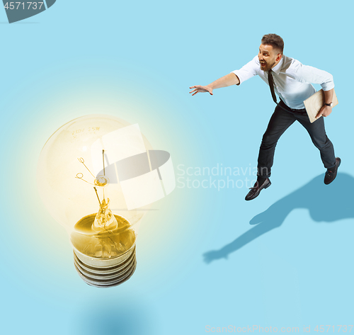 Image of Concept of a new idea. A man going with a lamp