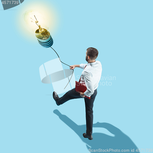 Image of Concept of a new idea. A man going with a lamp