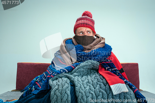 Image of Bearded Man with Flue Sitting on Sofa at Home. Healthcare Concepts.