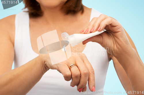 Image of close up of senior woman applying hand cream