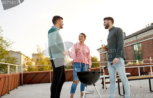 Image of happy friends having bbq party on rooftop