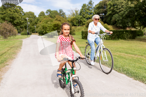 Image of grandmother and granddaughter cycling at park