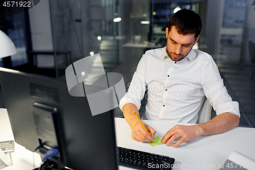 Image of businessman with computer working at night office