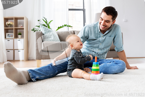 Image of father playing with little baby daughter at home