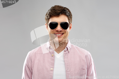 Image of smiling young man in shirt and aviator sunglasses