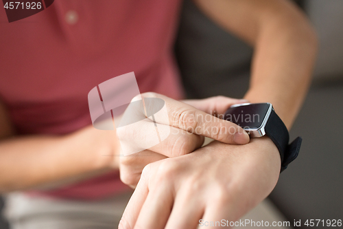 Image of close up of male hands with smart watch