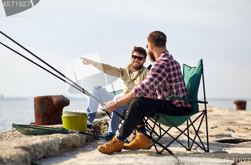 Image of happy friends with fishing rods on pier