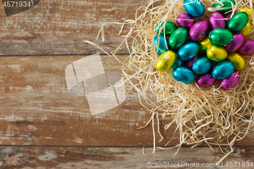 Image of chocolate eggs in foil wrappers in straw nest