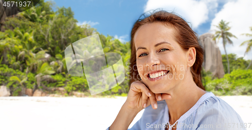 Image of portrait of happy smiling woman on summer beach