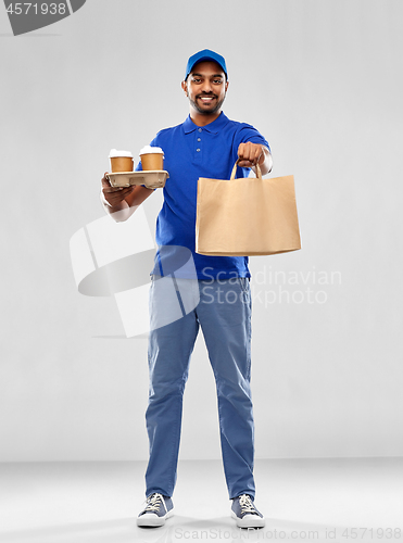 Image of happy indian delivery man with food and drinks