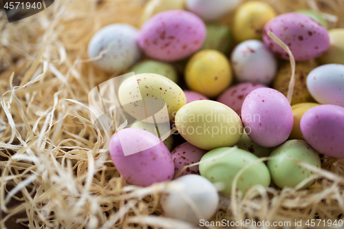 Image of close up of easter egg candies in straw nest