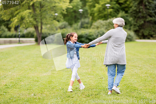 Image of grandmother and granddaughter playing at park